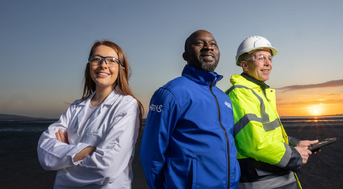 Science, admin and Leakage reduction programme employees standing together, smiling, at sunrise