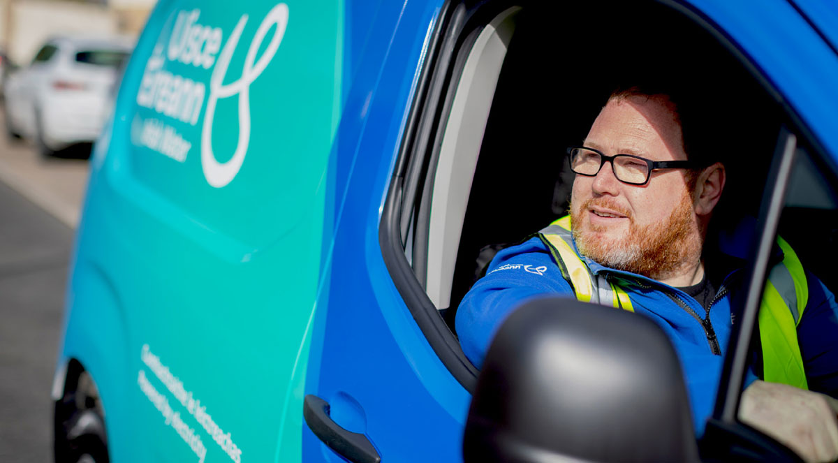 Smiling Uisce Eireann fleet driver seated inside a branded van