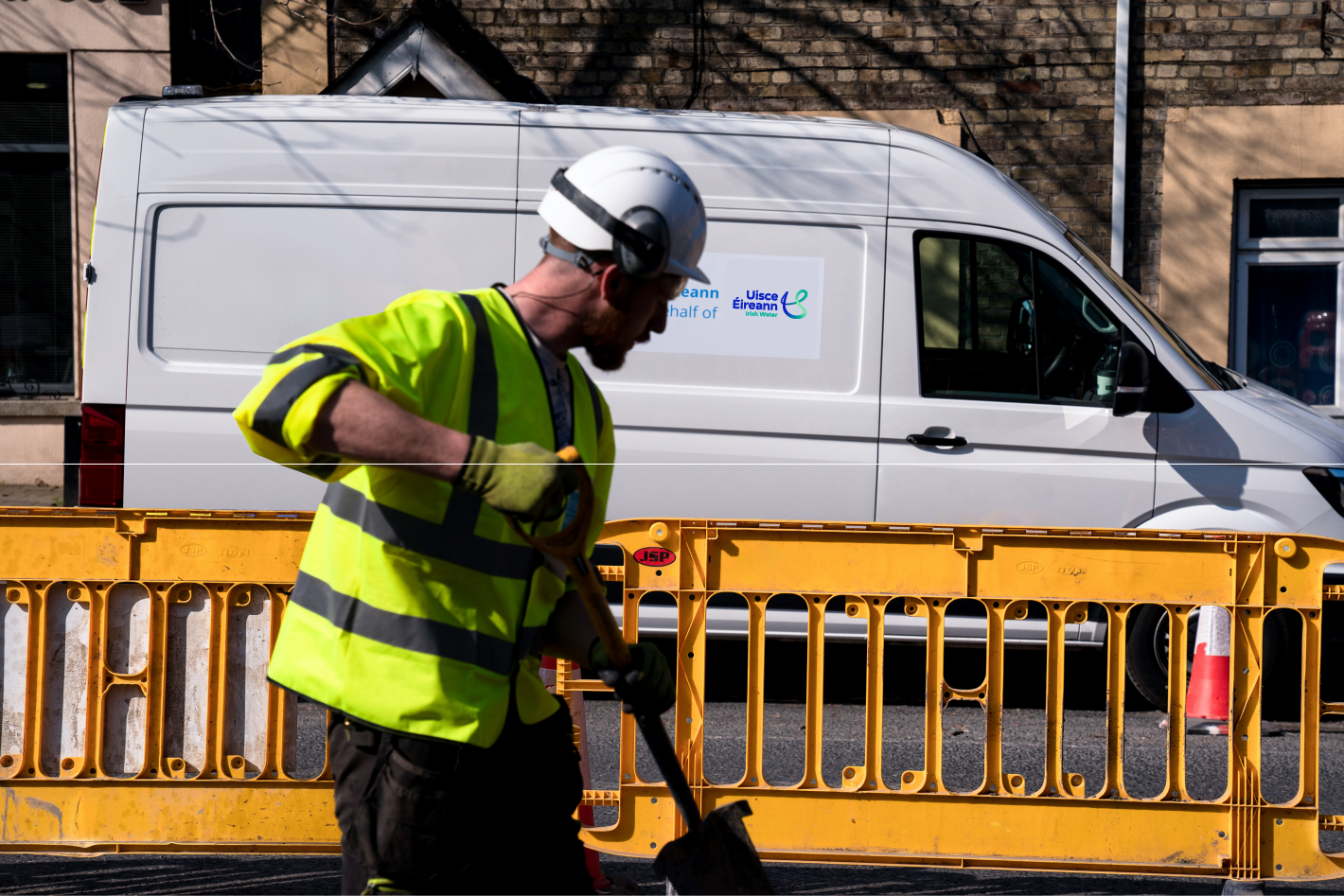 Uisce Éireann workers digging up the road with a shovel in hand
