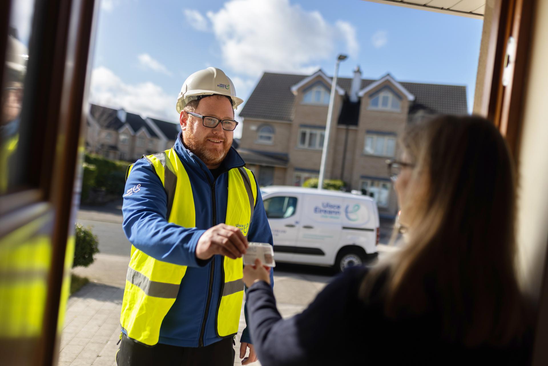 An Uisce Éireann employees interacting with a customer in their home