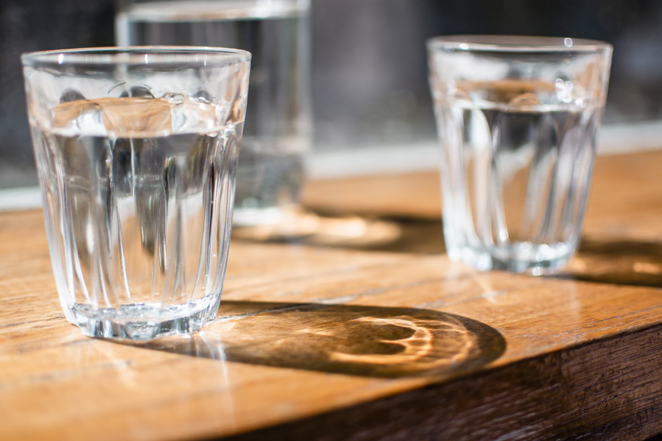 Close up of two glasses of water sitting on a table