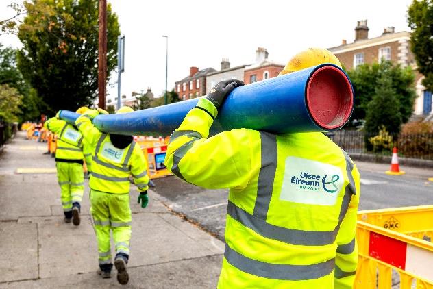 Uisce Éireann workers carrying a pipe
