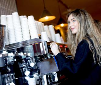 A barista making coffee in a coffee shop