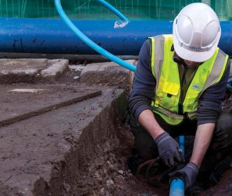 Uisce Éireann worker fixing a water pipe on a road