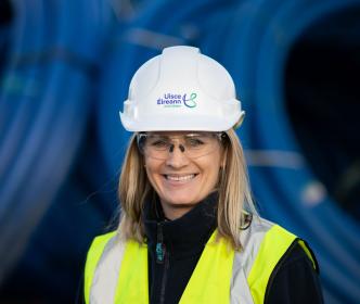 Lisa Cogan wearing safety equipment with goggles, high visible jacket and a hard hat